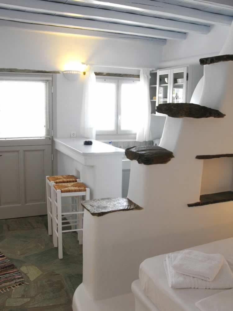 Altair studio, avec un double lit, un sofa-lit traditionnel propre au style particulier des Cyclades, une cuisine américaine, une salle de bains, TV, Vega Apartments in Tinos island, Cyclades